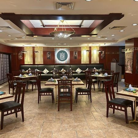 Safir Hotel Cairo Giza Exterior foto The photo shows the interior of a restaurant. The space features a combination of warm wood tones and elegant decorations. There are several dining tables arranged throughout, each set with plates, cutlery, and decorative napkins. The walls are adorn