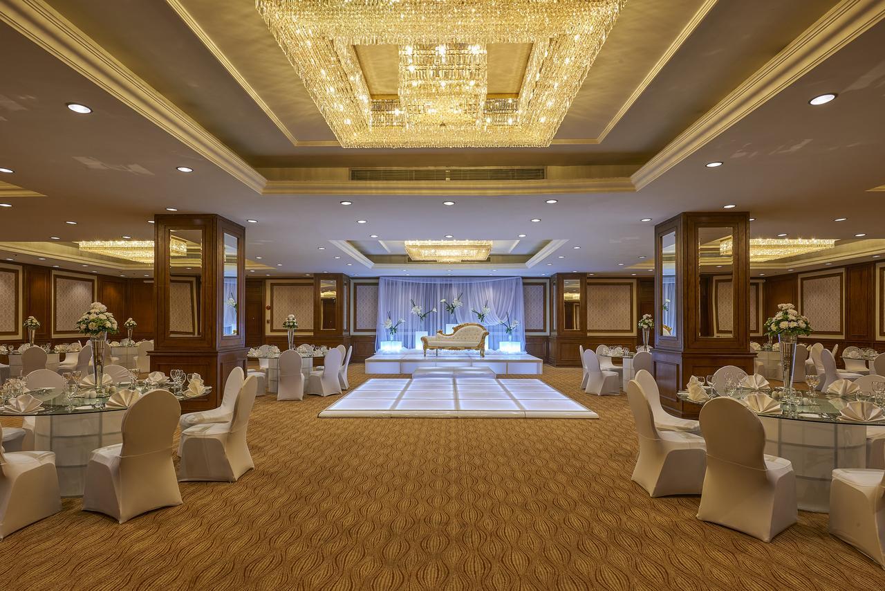 Safir Hotel Cairo Giza Exterior foto The photo shows an elegantly decorated event space. The room features a beautiful chandelier hanging from the ceiling, providing a warm glow. In the center, there is a raised platform that appears to be set up for a ceremony or celebration. Surroundi